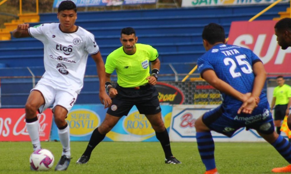 Randall Row Solano trata de evadir la marca de Jean Carlos Sánchez, en un tramo del cerrado juego entre Grecia y Sporting.